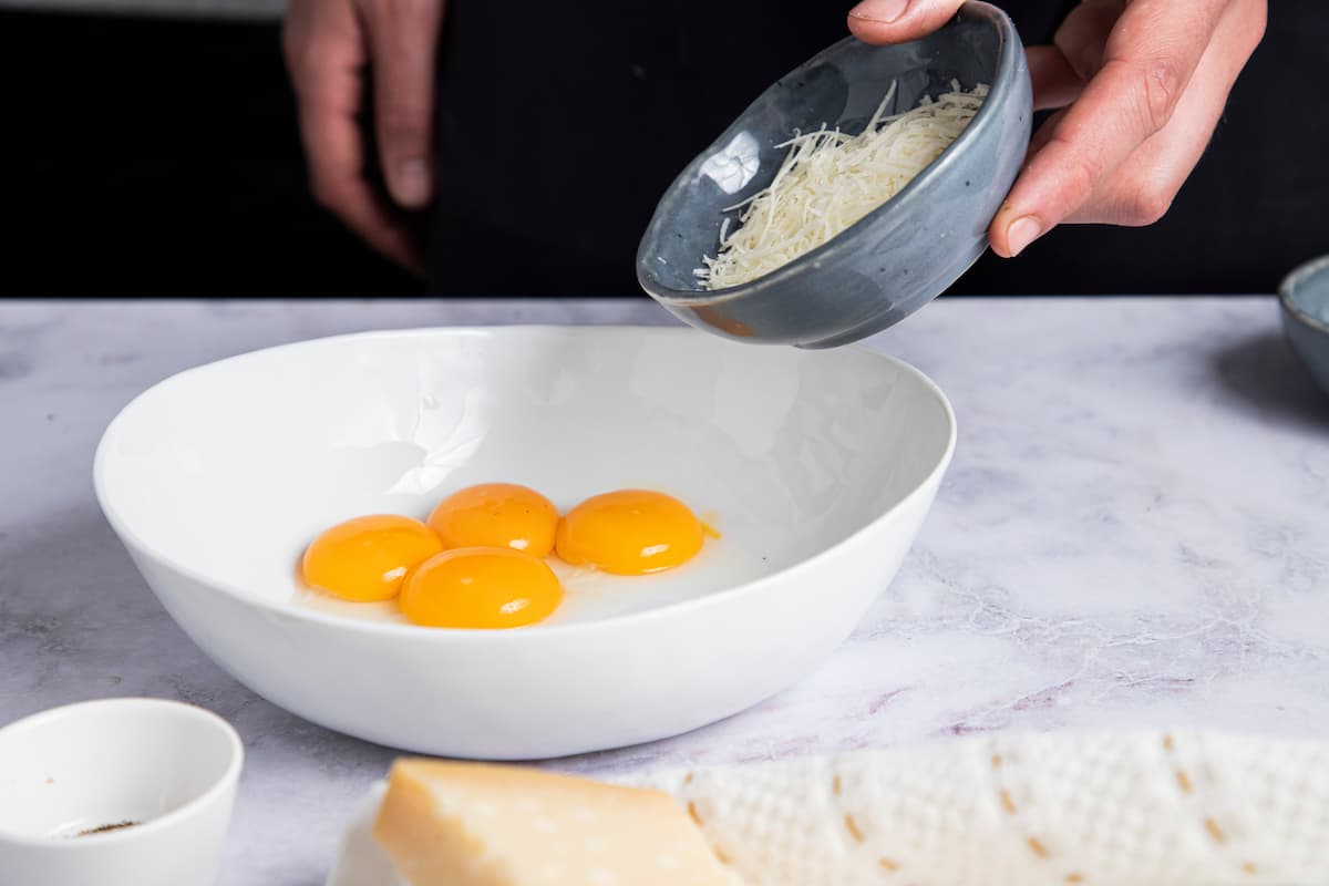 Receta Espagueti a la carbona. Paso 2: Mezcla en un bol las yemas de huevo, el queso y la pimienta negra